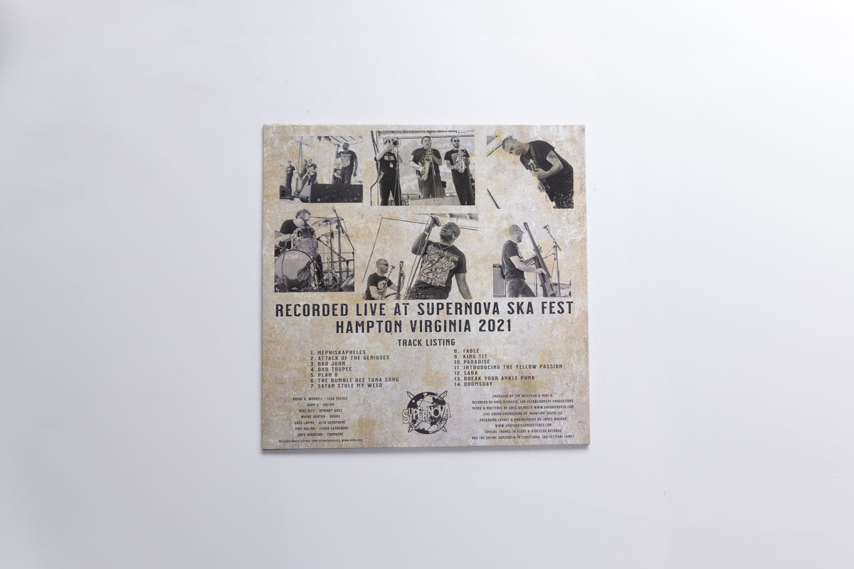 A square printed cover or poster mounted against a plain light gray wall. The artwork has a distressed beige background with multiple small black-and-white photos arranged in a collage, plus black text reading 'RECORDED LIVE AT SUPERNOVA SKA FEST HAMPTON VIRGINIA 2021' and additional track/artist text below.