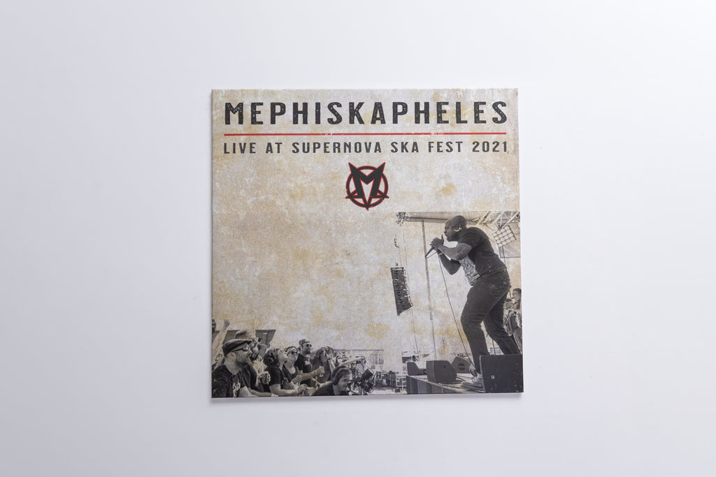 A square album or print cover for Mephiskapheles titled 'Live at Supernova Ska Fest 2021', shown hanging against a plain light gray wall. The cover has a distressed beige background with black text, a red logo, and a black-and-white photo of a performer on stage.